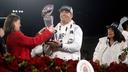 Penn State head football coach James Franklin is presented with the Rose Bowl trophy as President Bendapudi looks on.