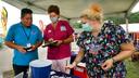 Luis Angel Guzman, a 19-year-old carnival ride worker from Mexico, talks with Wayne Memorial Community Health Center nurses at the Wayne County Fair before he got the Johnson & Johnson vaccine.