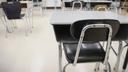 Desks are shown in a classroom.