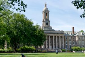 People walk across Old Main lawn on the Penn State campus on Wednesday, May 19, 2021.  